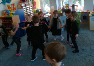 Dzieci tańczą tworząc małe kółeczka.